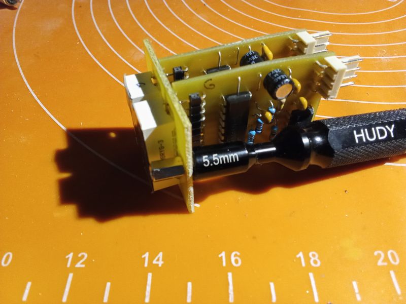 Printed circuit board with a Hudy tool next to it.