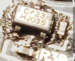 Zbliżenie płytki PCB z układem SMD z nadrukiem „C423” i „HJ035”