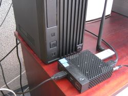 Two computers: a Dell Wyse 3040 mini PC with cables and a larger black tower on a red tabletop