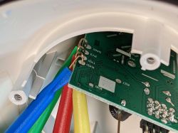 Colored wires connected to a small green printed circuit board inside a plastic casing.