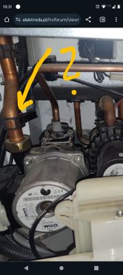 Zbliżenie na część instalacji hydraulicznej z pompą i rurami.