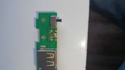 Zielona płytka PCB z gniazdem USB-A i małym złączem; widoczne uszkodzone pola lutownicze