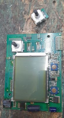 Damaged PCB with LCD display and two rotary encoders, one detached