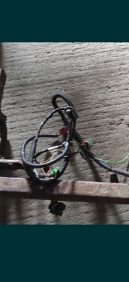 Widok wiązki elektrycznej z zielonymi i czerwonymi złączami leżącej na betonowej powierzchni.