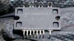 Obraz ukazuje moduł elektroniczny STK5Q4U363J z wystającymi metalowymi nóżkami.