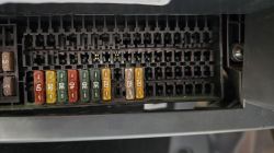 Skrzynka bezpieczników samochodowych z kolorowymi bezpiecznikami oznaczonymi wartościami liczbowymi.