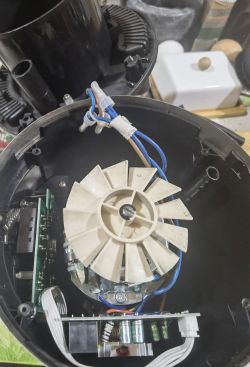 Wnętrze urządzenia elektronicznego z widocznym wirnikiem i okablowaniem.
