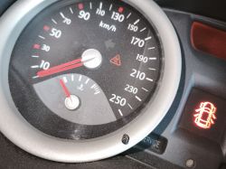 Zbliżenie na wskaźniki prędkości i temperatury w Renault Megane z ikoną kontroli trakcji