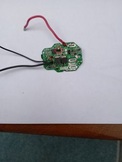 Płytka PCB z przewodami; na układzie w czerwonym kółku niewyraźny symbol lub napis.