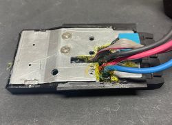 Moduł elektroniki w czarnej obudowie z metalową płytą i wiązką przewodów zatopioną w żółtej masie