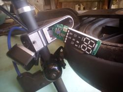 Zdemontowany panel sterowania elektrycznej hulajnogi z widoczną płytką PCB i wyświetlaczem LED.