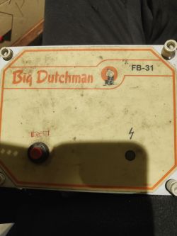 Panel urządzenia Big Dutchman FB-31 z czerwonym przyciskiem i oznaczeniem pioruna