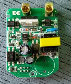 Zbliżenie płytki drukowanej z elektronicznymi komponentami, takimi jak kondensatory, rezystory i złącza.