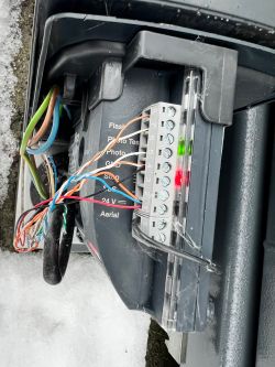 Zbliżenie na zaciski sterownika napędu bramy Nice RD400 z podłączonymi przewodami.