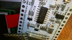 Zbliżenie na obwód drukowany z różnymi komponentami elektronicznymi i oznaczeniami.