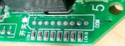 Close-up of a circuit board with visible pins and COM label.
