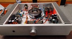 Wnętrze wzmacniacza audio DIY z transformatorem toroidalnym i komponentami elektronicznymi