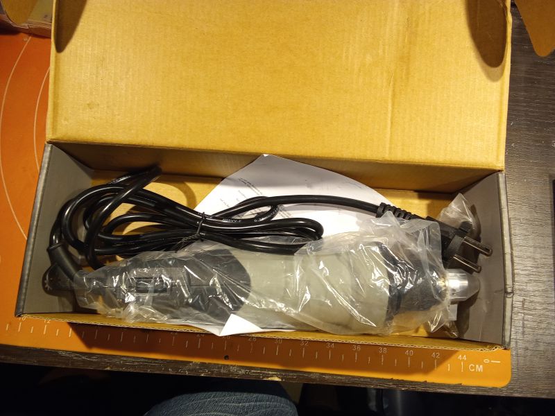 Szlifierka w kartonowym opakowaniu, zabezpieczona plastikową folią, z dołączonym kablem zasilającym i instrukcją.