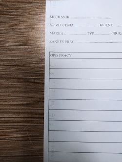 Wadliwy wydruk z drukarki z powtarzającymi się odbiciami tekstu po lewej stronie.