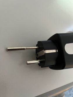 Two-pin electrical plug on a grey surface.
