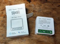 Sterownik smart SB490 i jego opakowanie na drewnianym blacie.