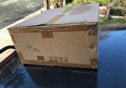 Large taped cardboard box on a glossy outdoor surface.