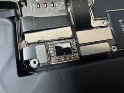 Uszkodzony układ scalony w pobliżu gniazda baterii na płycie głównej iPhone 13 Pro.