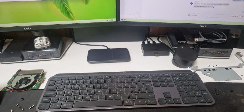 Computer Setup with Monitors and Peripheral Devices Desk with two monitors, a keyboard, and various electronic devices.