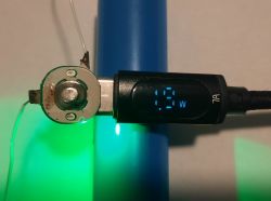 Damaged AA Battery and Power Measurement of 1.3 W Close-up of a damaged AA battery interior with a USB display showing 1.3 W.