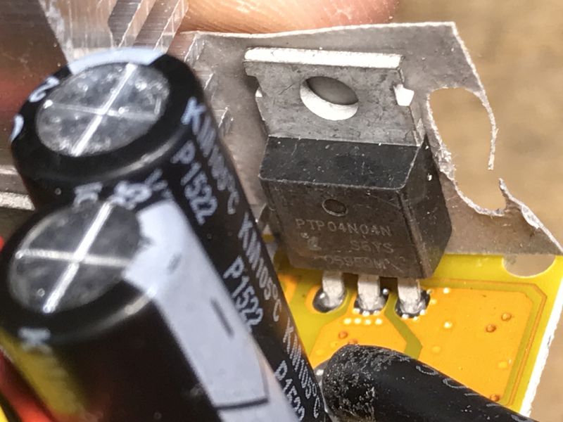 Zbliżenie na tranzystor PTP04N04AN i kondensatory na płytce PCB.