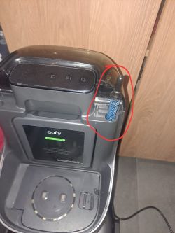 Stacja czyszcząca Eufy z zamontowanym niebieskim wężykiem w otworze, oznaczona czerwonym okręgiem