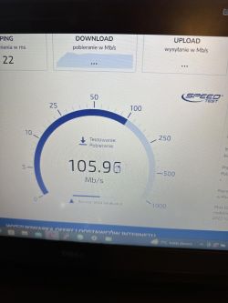 Ekran z wynikami testu prędkości internetu, pokazujący prędkość pobierania 105,96 Mb/s.
