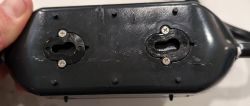 Power Adapter Housing with Two Screws Close-up of a black housing with two screws on the side.