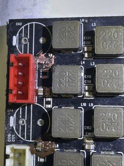 Zbliżenie na płytkę drukowaną z elementami elektronicznymi i czerwonym złączem.