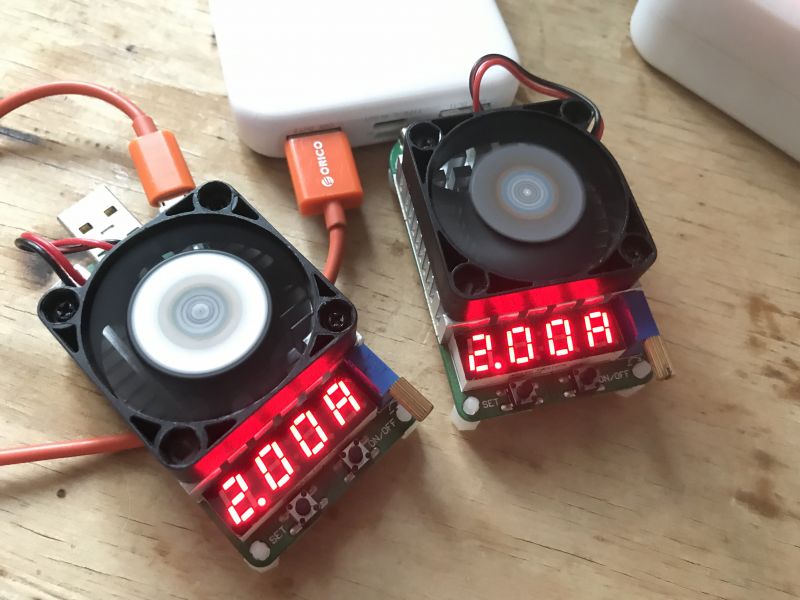 Dwa testery mocy USB z wentylatorami i wyświetlaczami, pokazujące 2.00A