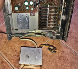 Widok wnętrza tunera T-7010 z widocznymi elementami elektronicznymi i odłączonym transformatorem.