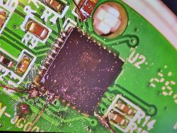Macro photo of a green PCB with a black integrated circuit and markings U2 and R14