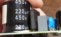 Zbliżenie na kondensator 220µF 450V zamontowany na płytce PCB sprężarki