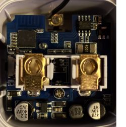 Close-up of a PCB with two gold spring contacts and surface-mount electronic components