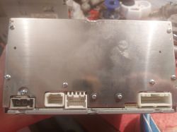 Metalowa obudowa urządzenia elektronicznego z widocznymi złączami i śrubami.