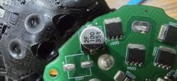 Okrągły kondensator SMD z oznaczeniami 2F, 100, 35t na płytce drukowanej.