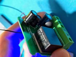 Close-up of a circuit board with connectors and a relay on a blue background.