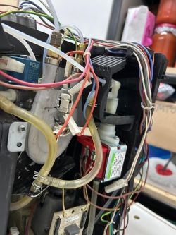 Wnętrze ekspresu do kawy z widocznymi przewodami, elektrozaworem i rurkami wodnymi