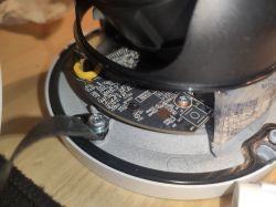 Wnętrze kamery z widocznymi płytkami PCB i śrubami montażowymi.