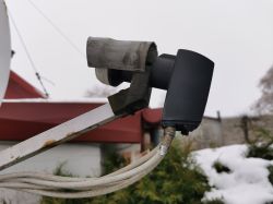 Satellite converter with a DIY snow shield made from a cut plastic pipe