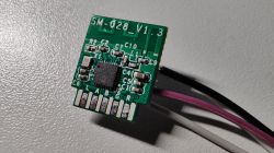 Circuit board with an integrated circuit labeled SM-028_V1.3, with connected wires in various colors.