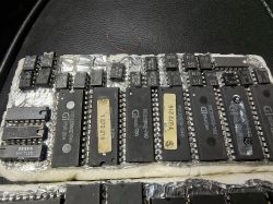 Rząd układów scalonych, w tym chipy TESLA i GI, ułożone na folii aluminiowej