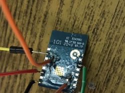 Electronic module with soldered wires on a wooden table.