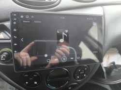 Ekran radia we wnętrzu samochodu Ford Focus Mk1 z włączonym odtwarzaniem muzyki.