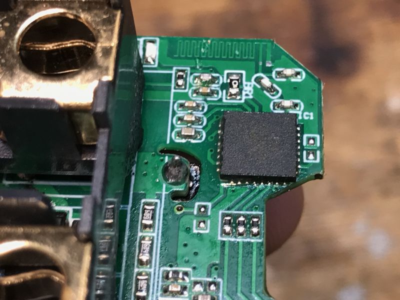 Circuit Board with Chip Close-up of a green circuit board with a chip and metal components.